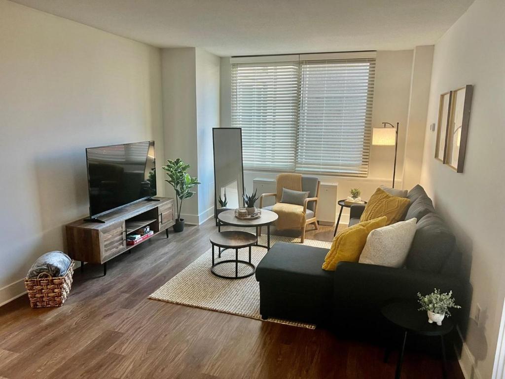 uma sala de estar com um sofá e uma televisão de ecrã plano em Comfy Getaway by DC,Metro,Airport em Arlington