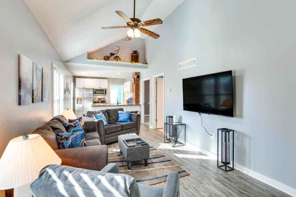 a living room with a couch and a flat screen tv at Charming Missouri Home Less Than 1 Mi to Katy Trail! in Pleasant Hill