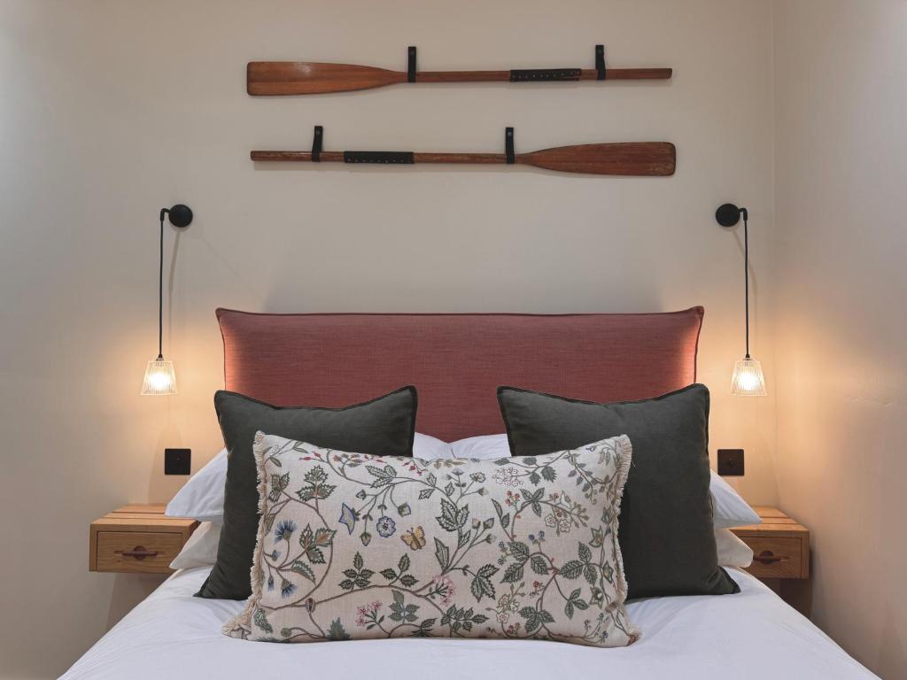 a bedroom with a bed with pillows and two lamps at Y Cwtch Cottage By Birch Stays in Rhosneigr