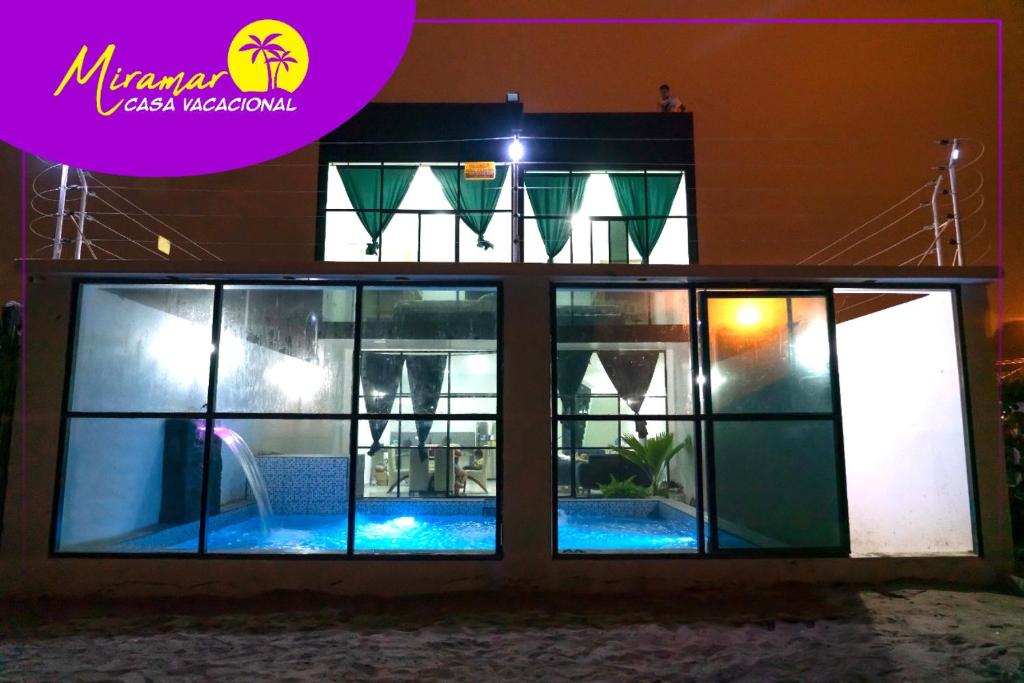 eine Villa mit einem Pool in der Nacht in der Unterkunft MIRAMAR Casa Vacacional Frente al mar in Tonsupa