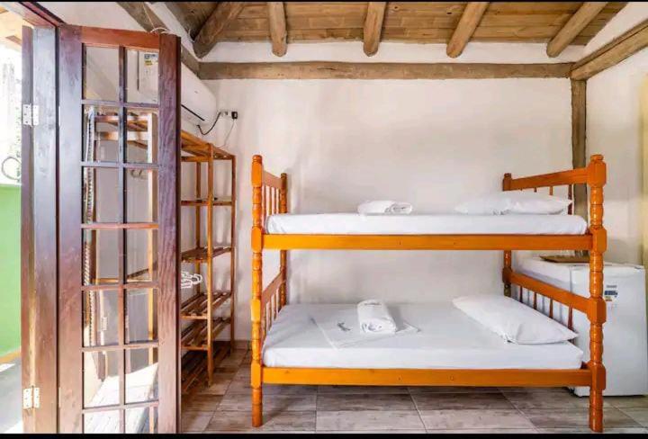 a room with two bunk beds in a room at Prumirim Surf Suítes in Ubatuba