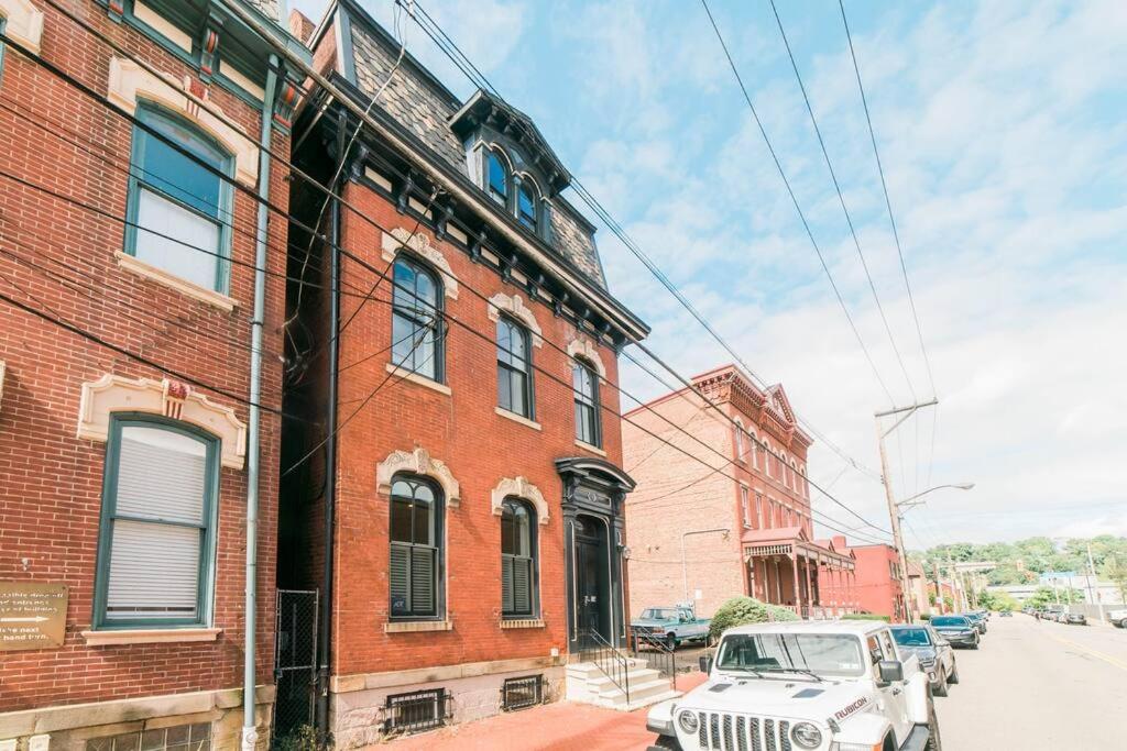 a white jeep parked in front of a brick building at Parking - Walkable - GroupStays - Washer in Pittsburgh