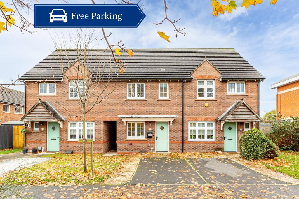 a red brick house with a free parking at Cosy 2 Bedroom Home in Wigan in Wigan