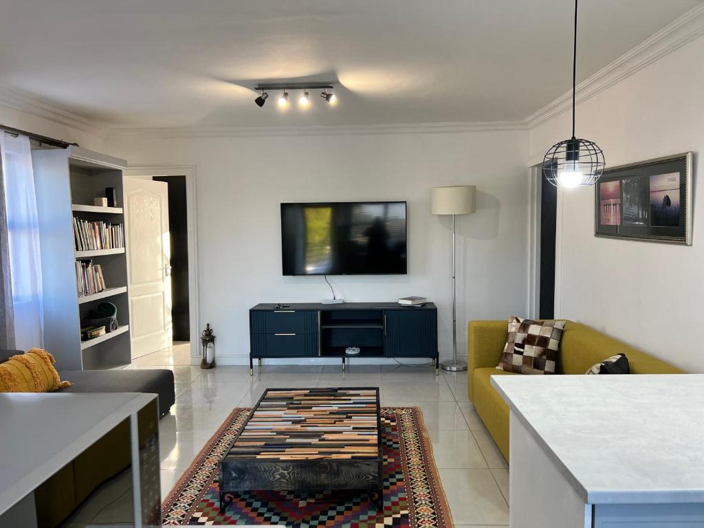 salon z kanapą i telewizorem w obiekcie G’s Self Catering Apartments w Kapsztadzie