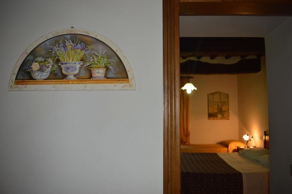 ein Schlafzimmer mit einem Fenster mit Topfpflanzen auf einem Regal in der Unterkunft Ospitalità Perusia in Tuoro sul Trasimeno