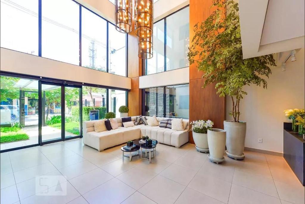 una gran sala de estar con sofás y plantas. en Living Design Vila Madalena, en São Paulo