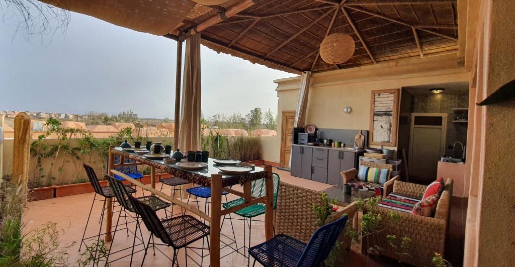 a patio with a table and chairs and a kitchen at Maison Mamdy in Marrakech