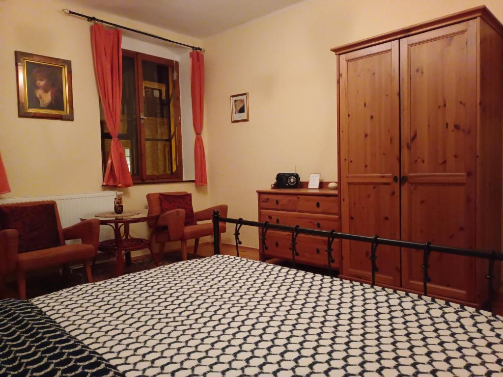 a bedroom with a bed and a cabinet and chairs at Guest House Olšakovský in Český Krumlov