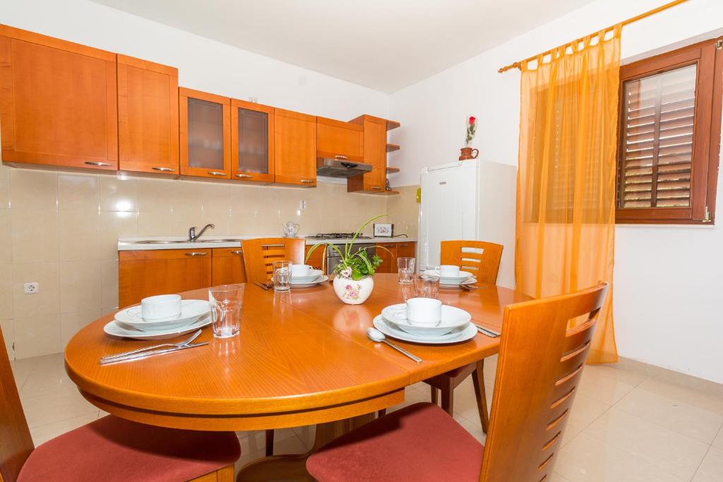 a wooden table in a kitchen with a dining room at Apartments Ana in Biograd na Moru