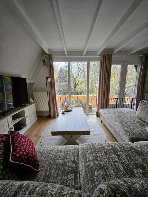 a living room with a couch and a coffee table at Het Hertenbos chalet 136 in Durbuy