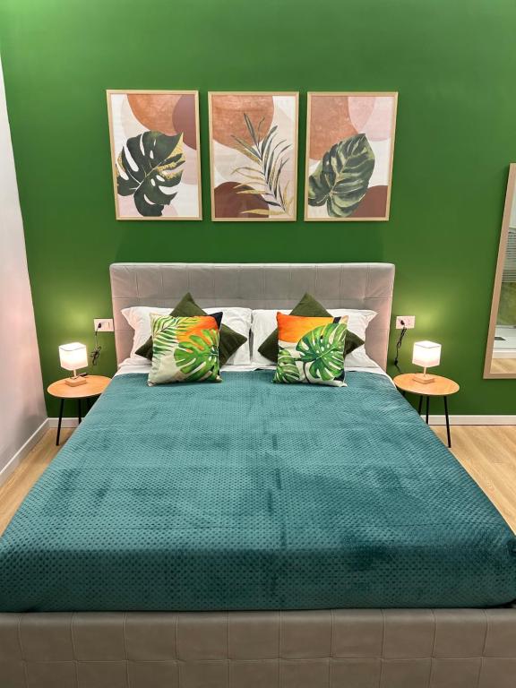 une chambre avec un grand lit aux murs verts dans l'établissement Vomero Suite and Deluxe Room B&B Napoli, à Naples