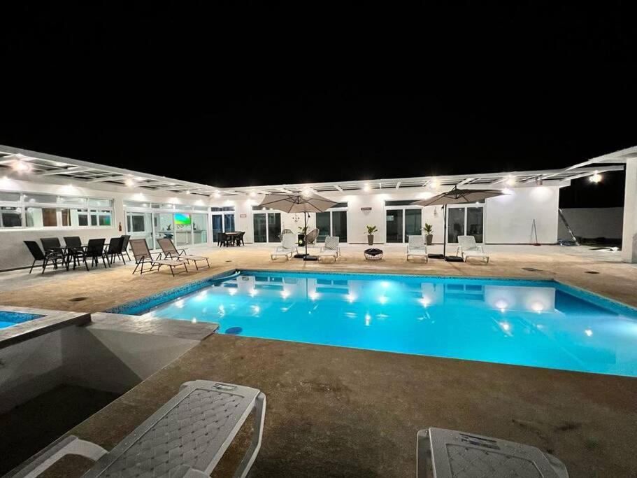 una piscina notturna con sedie e tavoli di Chalet full equipado - La Arenosa 