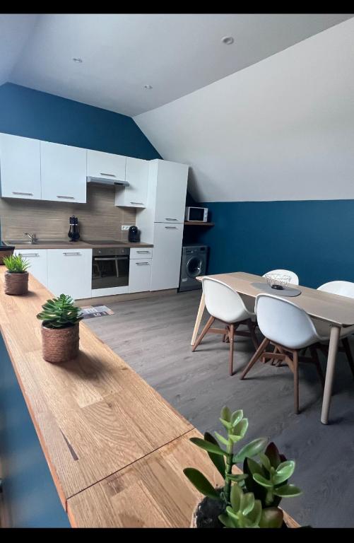 a kitchen and dining room with a table and chairs at Appartement Amiens-Camon in Camon