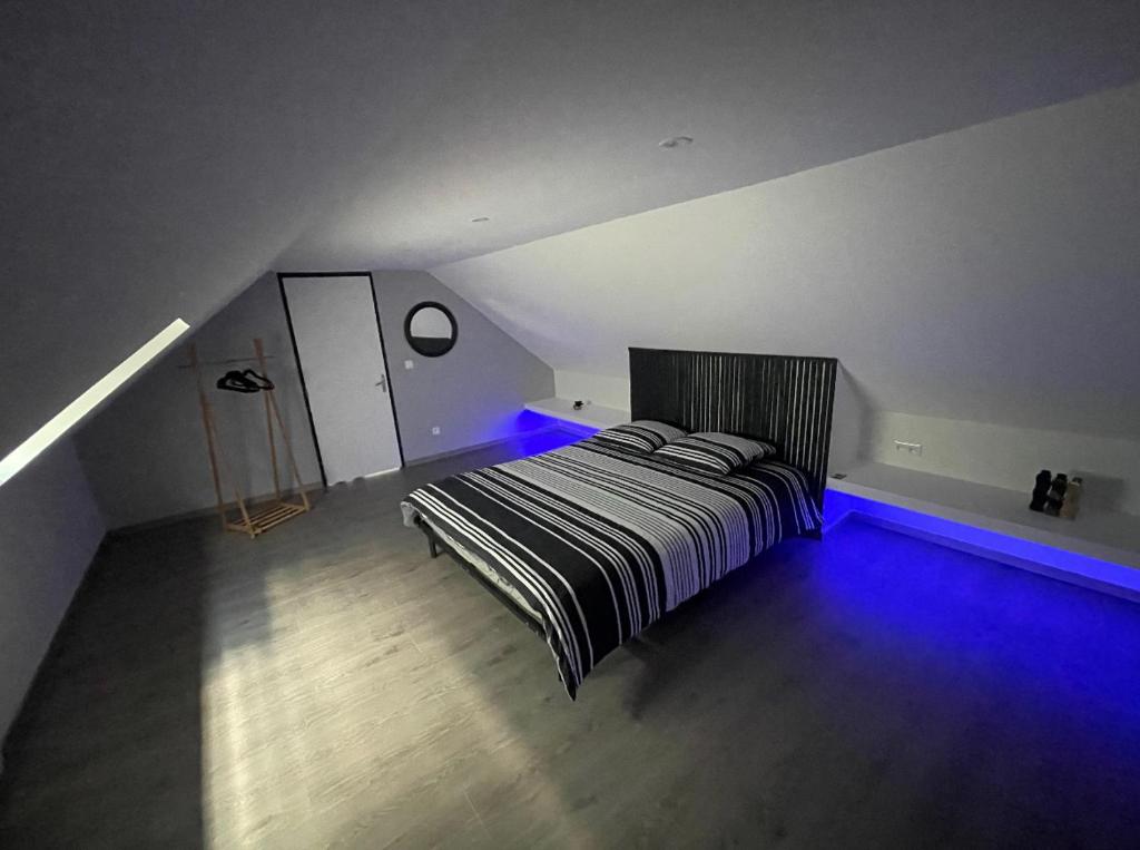 a bedroom with a bed with blue lights in it at Appartement Amiens-Camon in Camon