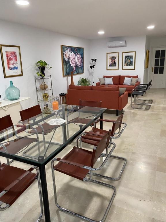 - un salon avec un canapé, des tables et des chaises dans l'établissement APARTAMENTO SAN JOSE, à Palma del Río