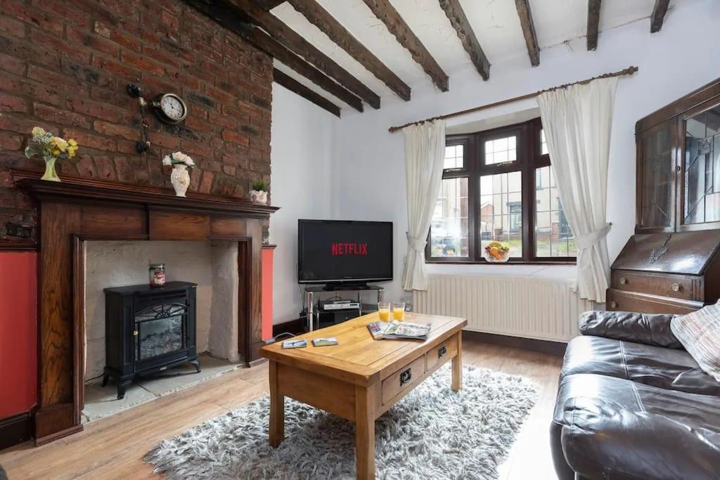 a living room with a couch and a fireplace at Linden Cottage in Coxhoe