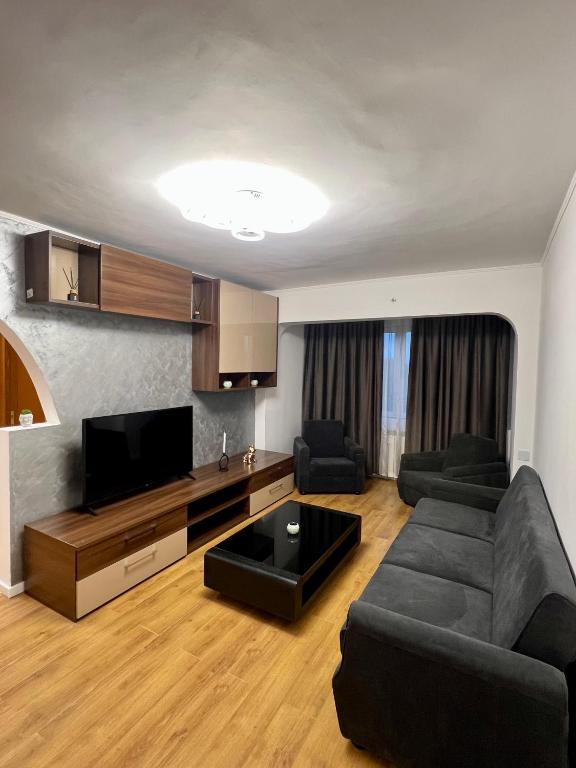 a living room with a couch and a flat screen tv at Best Rent Apartments in Giurgiu