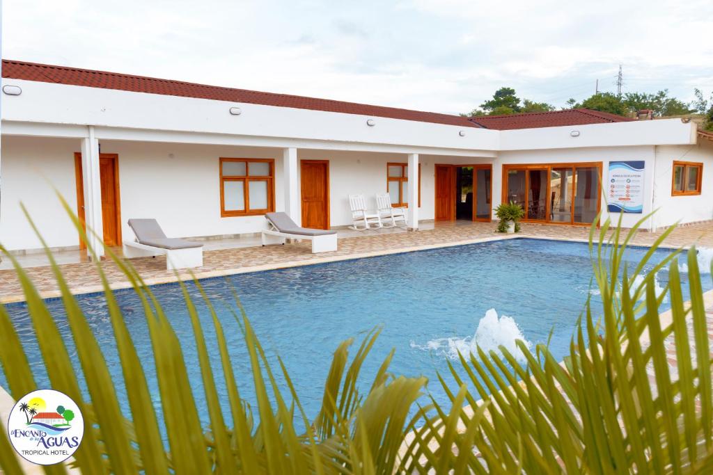 a house with a swimming pool in front of it at El Encanto de las Aguas in Necoclí