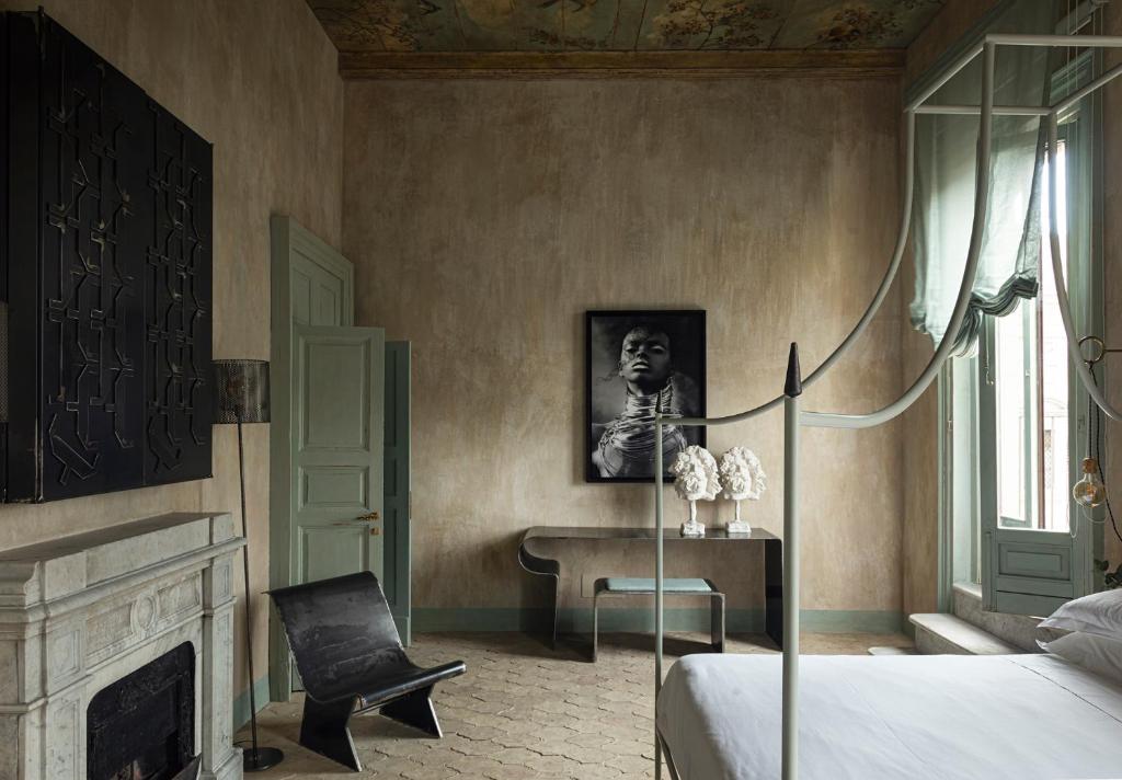 a bedroom with a bed and a chair and a desk at ELLE dimora di Sicilia in Catania