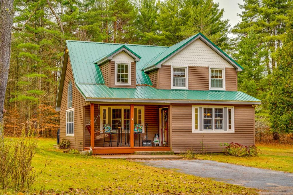 a house with a green roof on a yard at Cozy Greig Getaway - 1 Mi to Brantingham Lake! in Glenfield