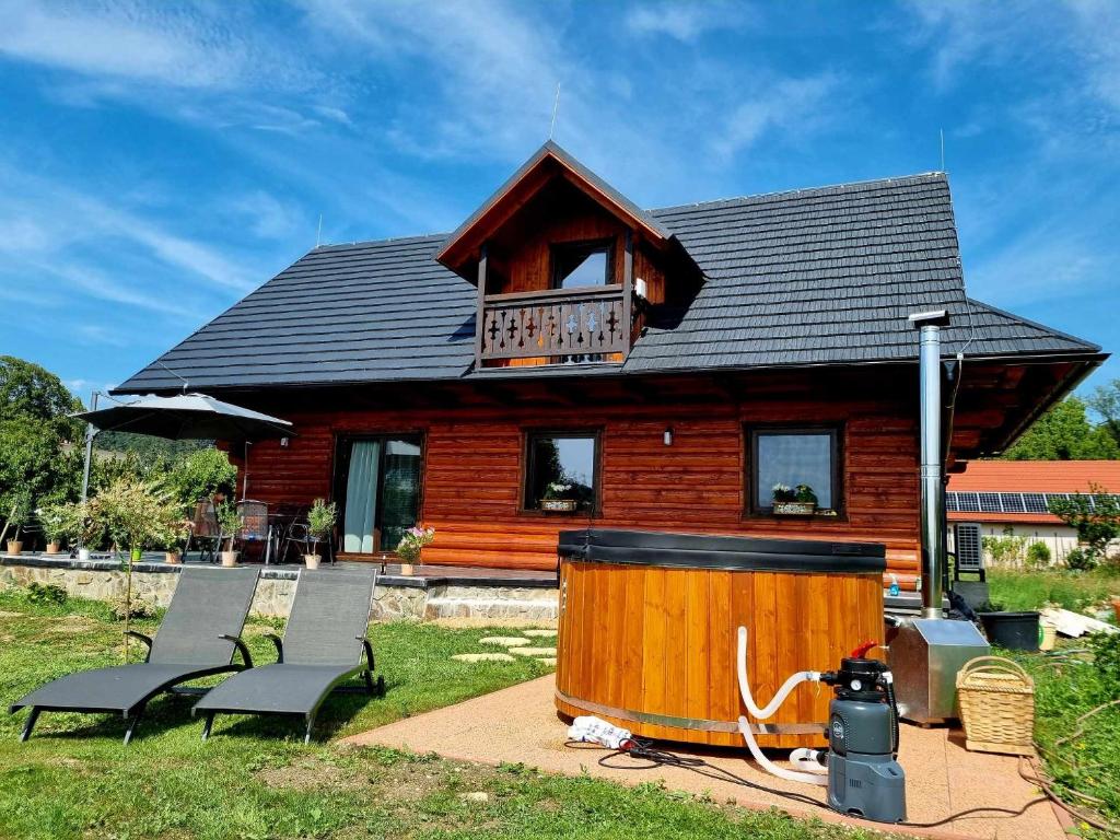 a log cabin with two chairs and a hot tub at Zrubík pod Znievom (Log Cabin Zniev) 