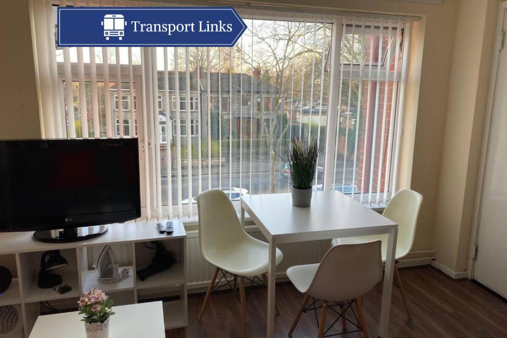 a white table and chairs in a room with a window at Studio in Stretford with Great Transport Links in Manchester