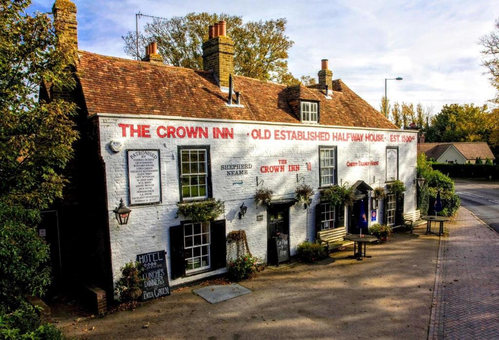 an old white building with a sign on it at The Crown Inn in Sarre