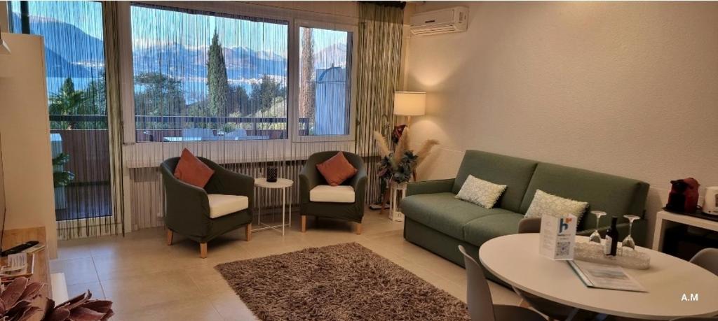 uma sala de estar com um sofá, uma mesa e cadeiras em Relax-Lugano Lake em Bissone