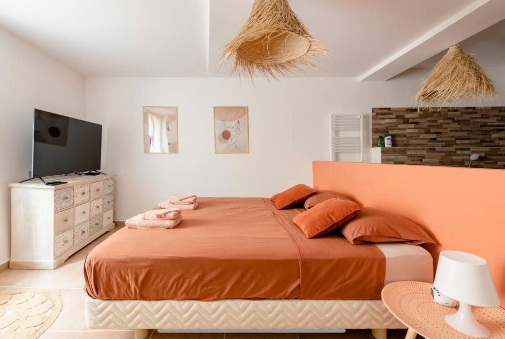 ein Schlafzimmer mit einem großen Bett mit orangefarbener Bettwäsche in der Unterkunft CASA RELAX Appart cocooning dans village provençal in Montfort-sur-Argens