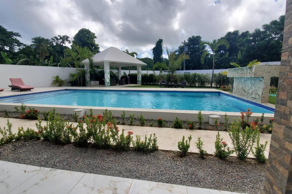 a swimming pool in a yard with flowers at So Lovely Apartment near Bonita Beach in Las Terrenas