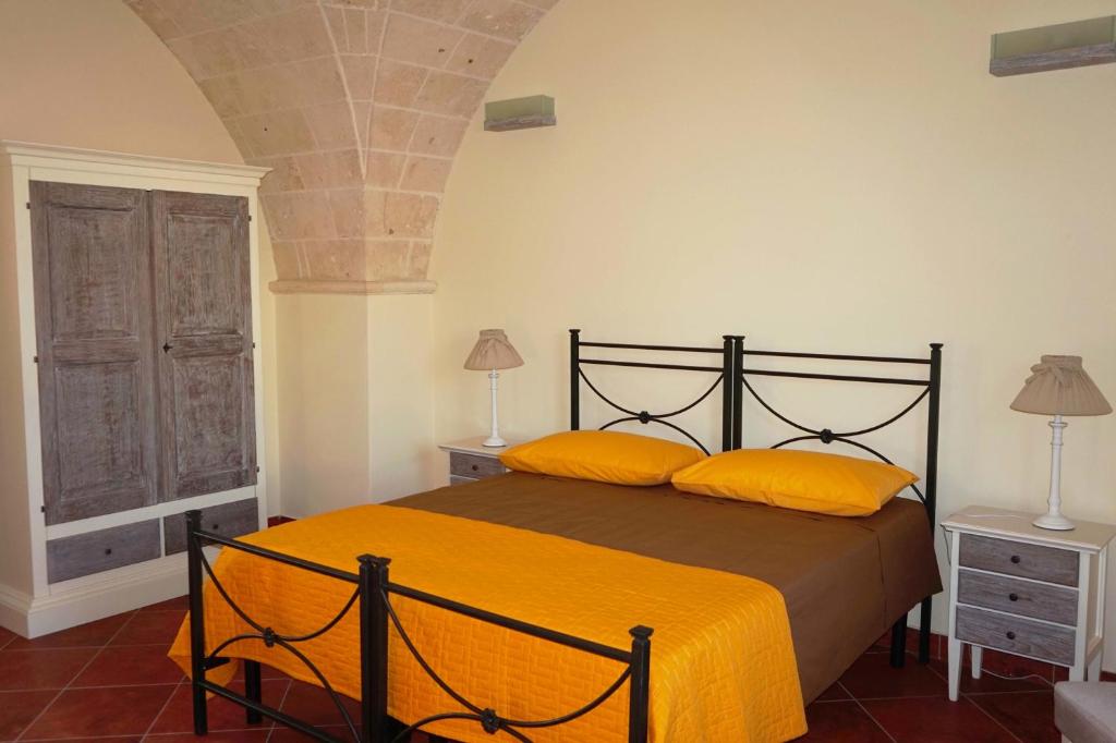 ein Schlafzimmer mit einem Bett mit gelben Kissen in der Unterkunft Masseria Pappo in Copertino