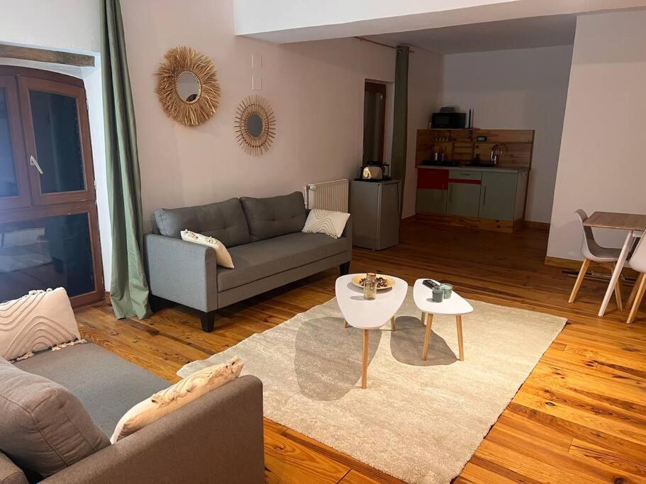 uma sala de estar com um sofá e uma mesa em Le chalet percheron em La Loupe