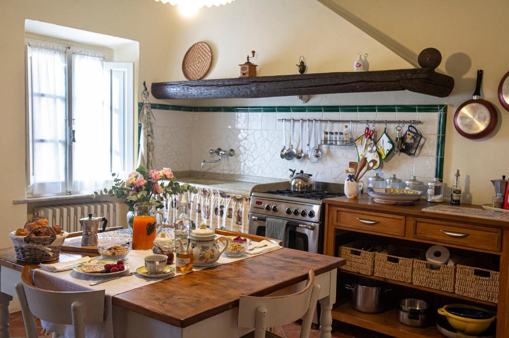 a kitchen with a wooden table and a stove at La Casetta Di Borgo in Lajatico