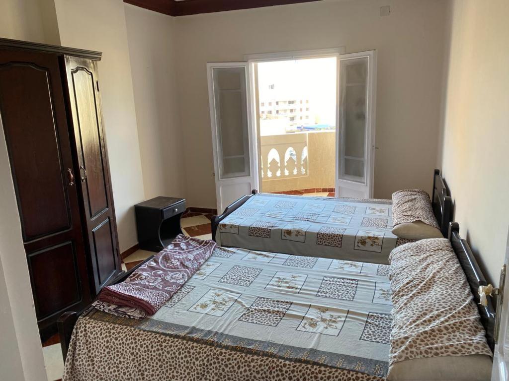 een slaapkamer met 2 bedden en een raam bij شقق فندقيه برج شيفورليه حي الدولار in Marsa Matruh