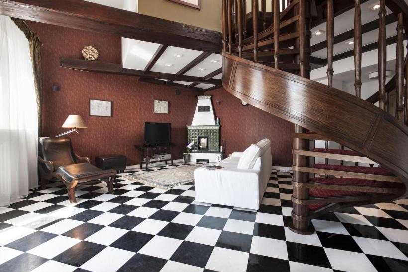 a living room with a staircase and a checkered floor at Royal Apartament in Krakow