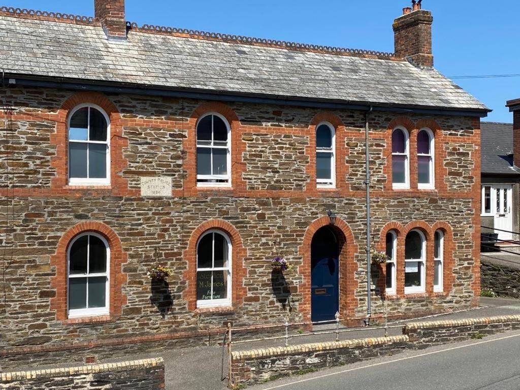 um velho edifício de tijolos com uma porta azul em Victorian Police Station Apartment em Launceston