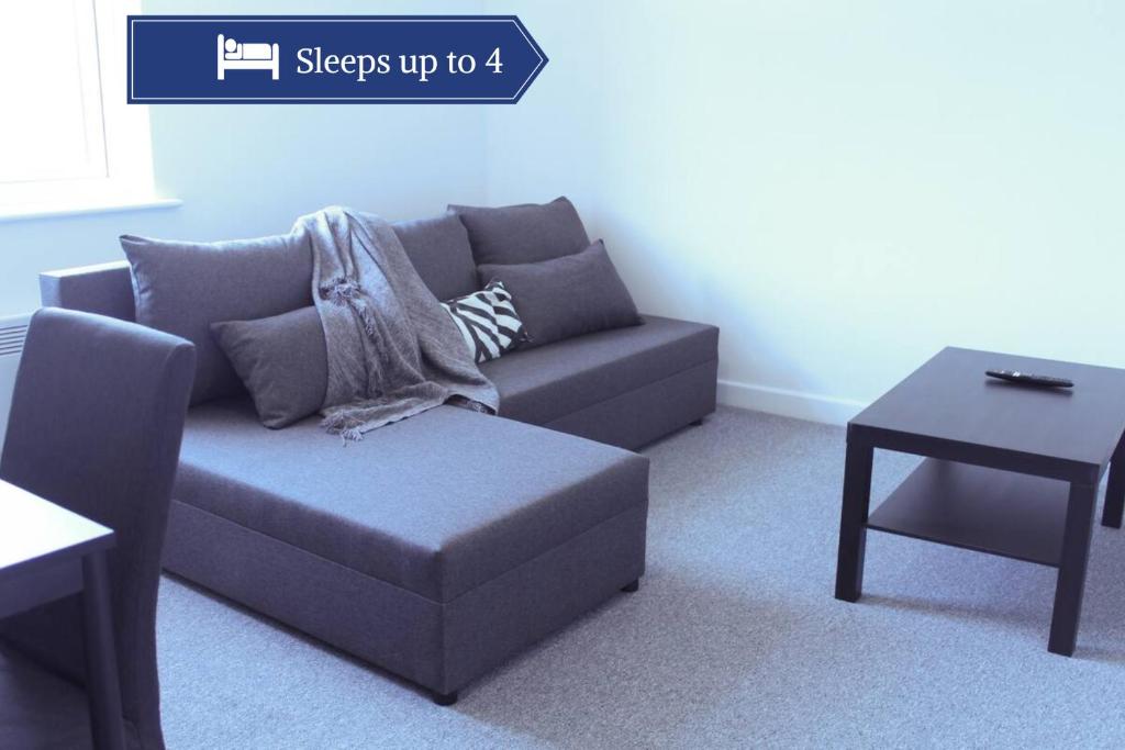 a living room with a couch and a table at Homely 1Bed Apt with Transport Links to CC in Heywood