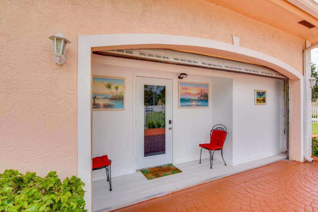 a garage with two red chairs and a door at Miami Gardens Studio with Patio 12 Mi to Ocean! in Miami Gardens