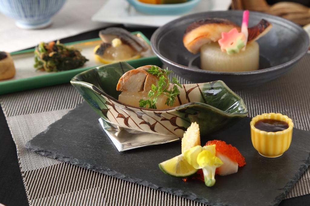 a plate with a bowl of food on a table at Hotel Binario Saga Arashiyama in Kyoto