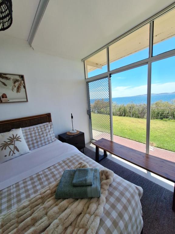 a bedroom with a bed and a large window at ON THE WATERS EDGE in Port Lincoln