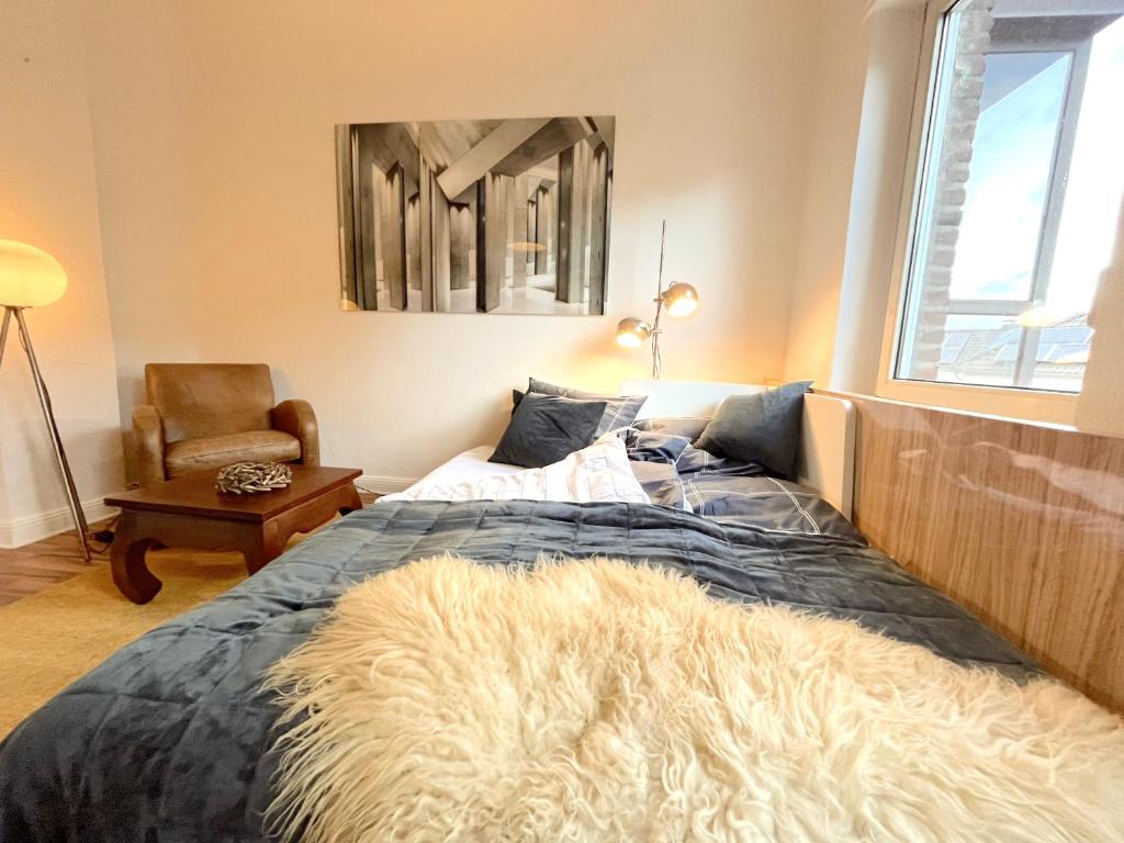 Un dormitorio con una cama con una manta peluda. en Dein Ankerplatz in Mülheim Ruhr - Traditionelle Zechenhaushälfte, en Mülheim an der Ruhr
