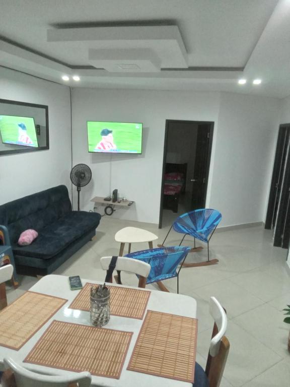 a living room with a couch and chairs and a tv at Hermosa y acogedora casa in Acacías