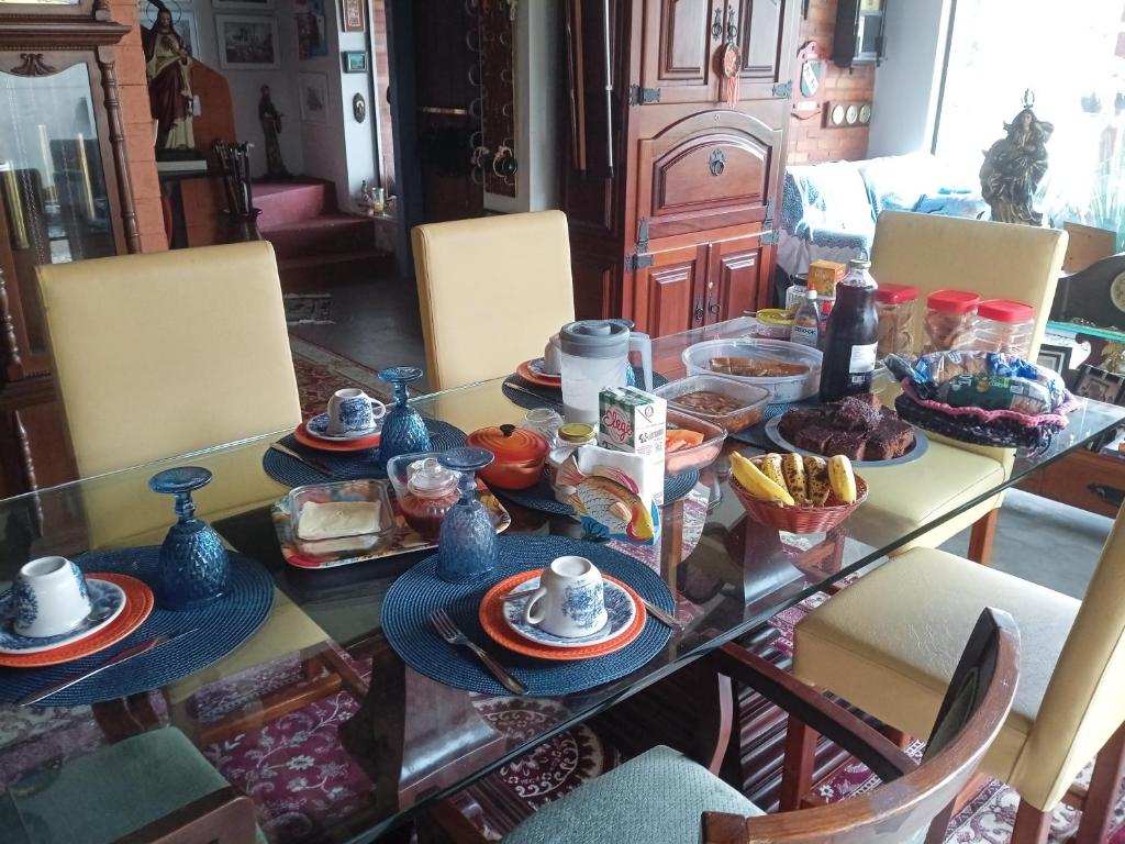 a dining room table with breakfast foods on it at QUINTAS DA BARRA BNB a 30m da praia in Balneario Barra do Sul