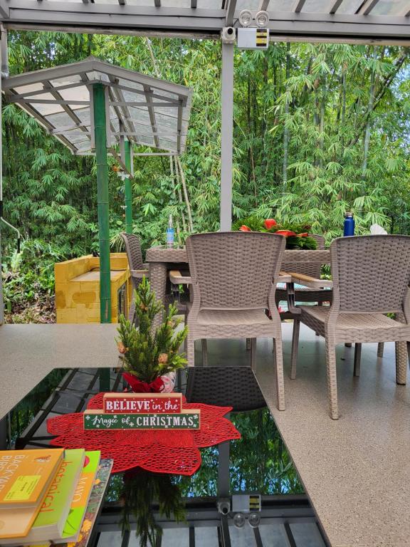 eine abgeschirmte Veranda mit einem Tisch und Stühlen in der Unterkunft CROSSROADS HAVEN FARM in Majayjay