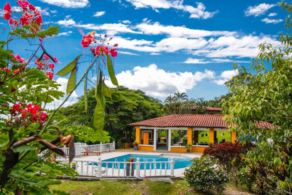 a villa with a swimming pool and a house at Hacienda Siete Sentidos in Anapoima