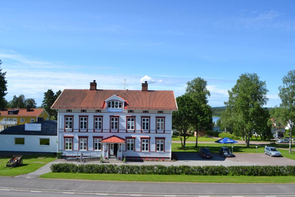 a large white house with a red roof at Varmland Hotel in Uddeholm