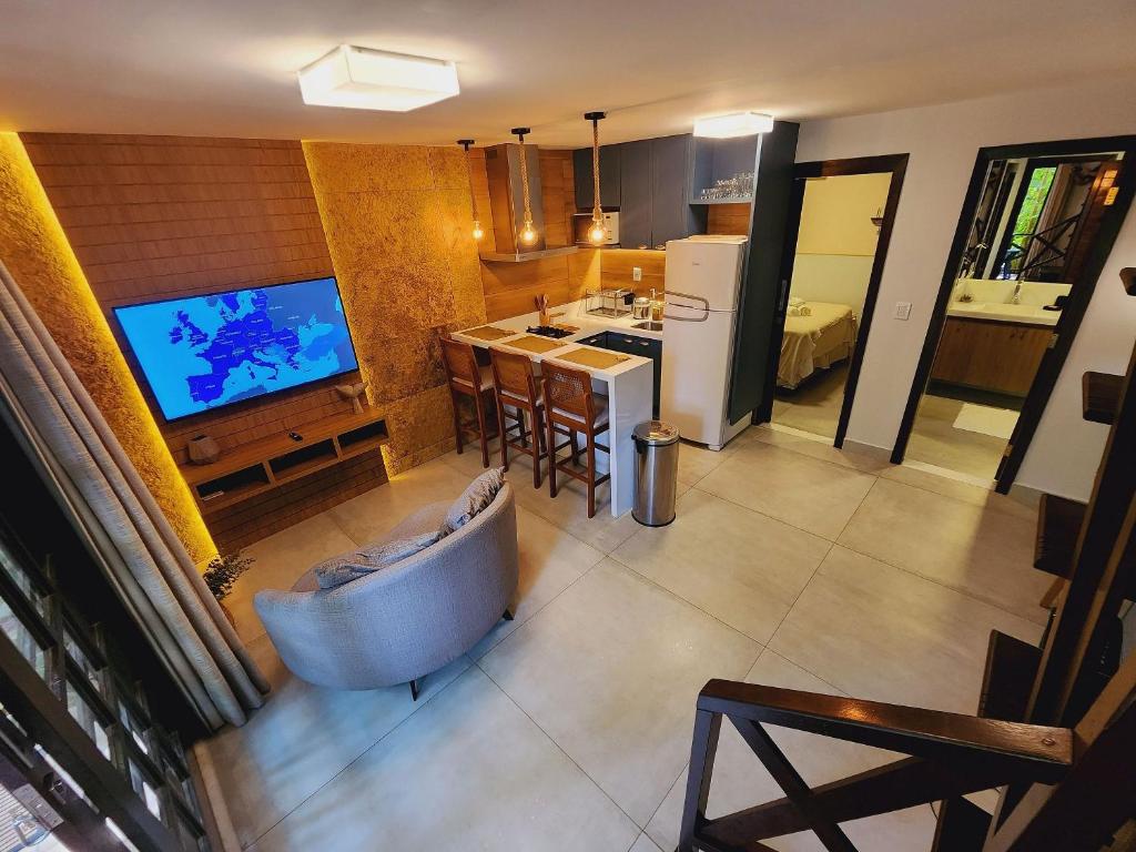uma cozinha com banheira e uma televisão num quarto em GP05 - Chalé em pousada a 300m da Praia do Amor em Pipa