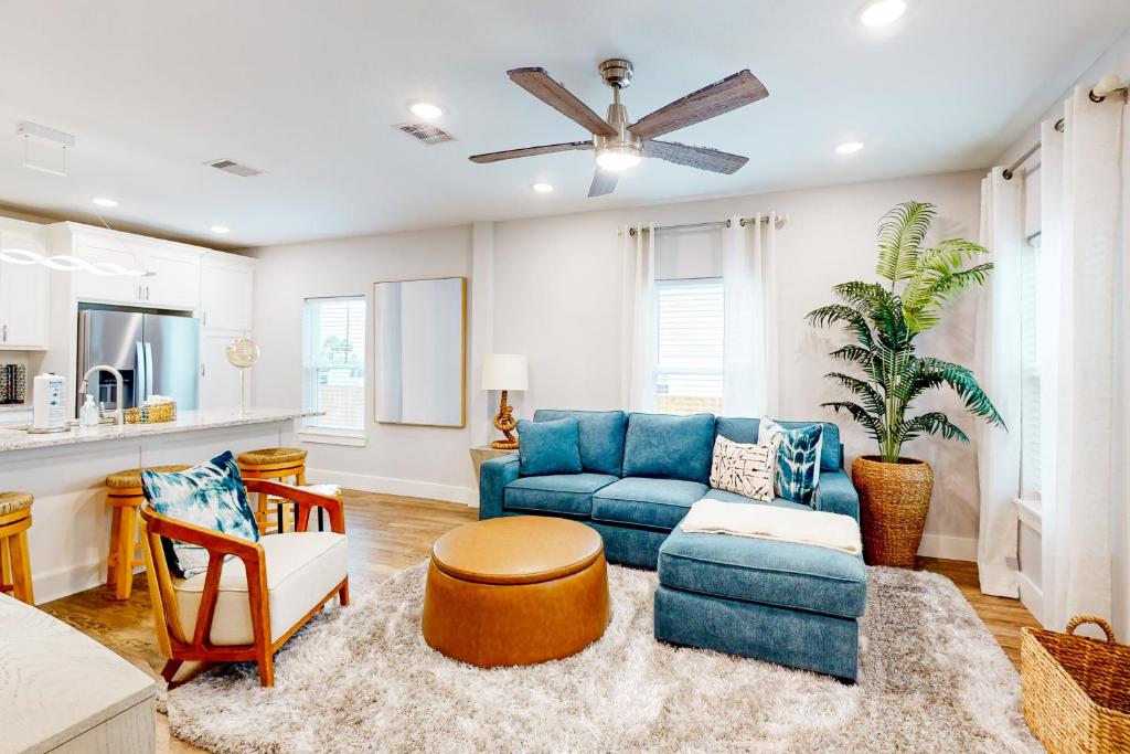 a living room with a blue couch and a table at The Driftwood Sanctuary in Galveston