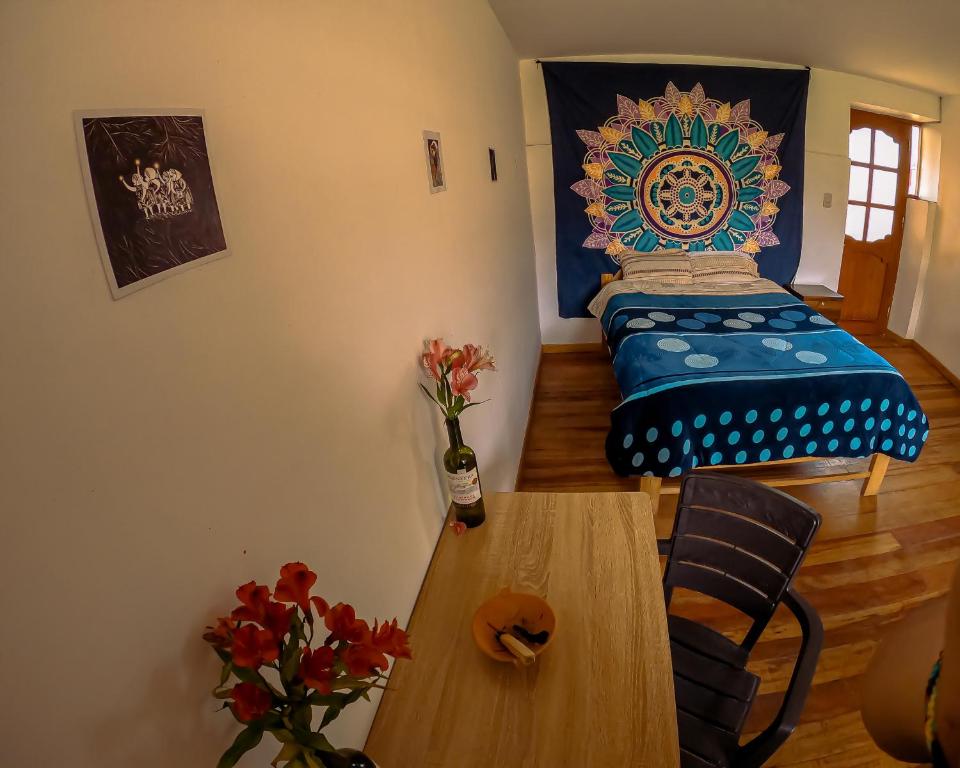 Habitación con cama y mesa con flores en Tayta Wasi Rent Pisac en Pisac