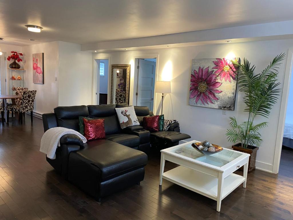 uma sala de estar com um sofá preto e uma mesa em Beautiful private full condo em Brossard